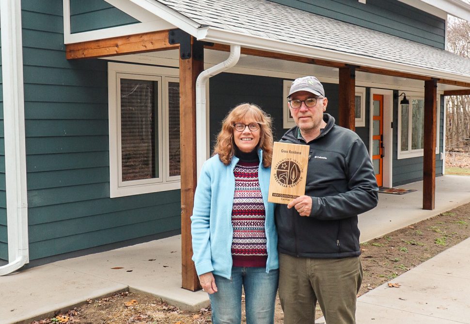 The Gross family holding their GreenStar Certified plaque at their front porch
