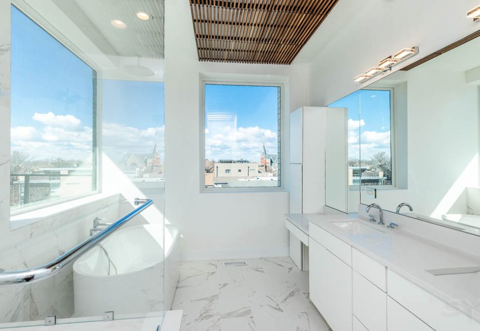 Bright condo bathroom with wide windows over the Chicago skyline
